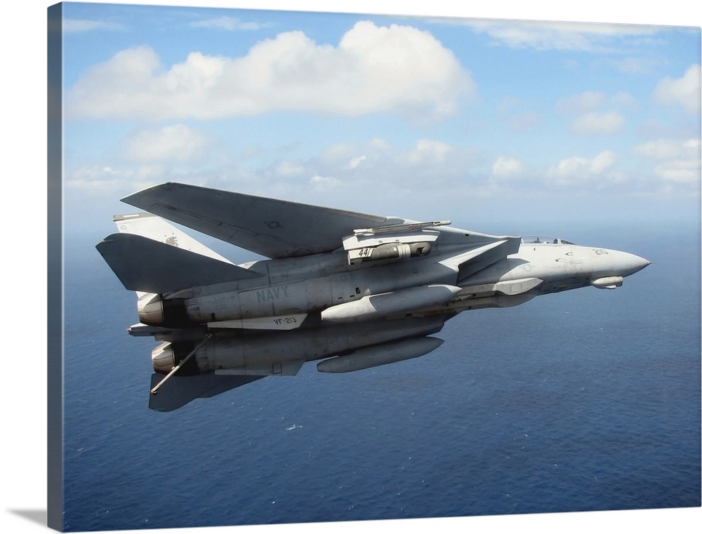 An F14D Tomcat banks with its tailhook lowered in preparation for landing
