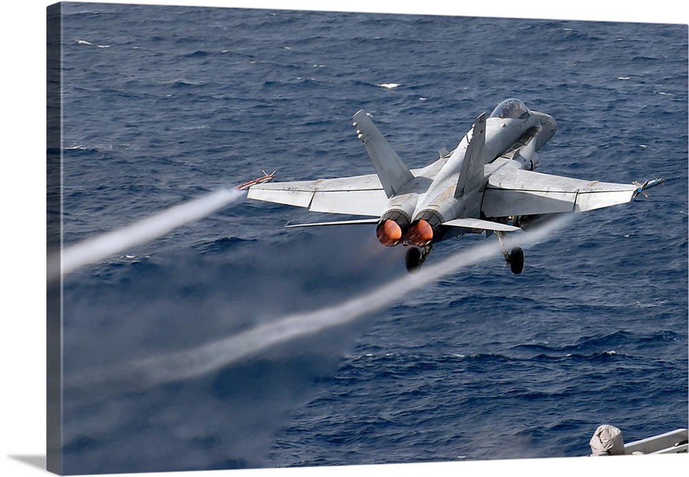 An F/A-18C Hornet launches off the flight deck of USS John C. Stennis.
