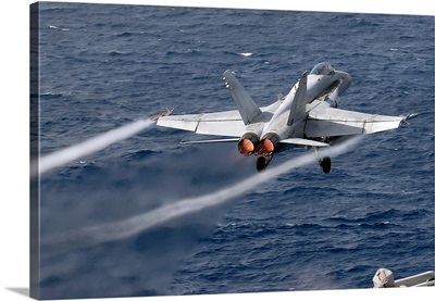 An F/A-18C Hornet launches off the flight deck of USS John C. Stennis