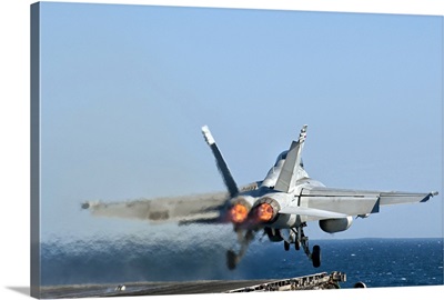 An F/A-18F Super Hornet launches from the flight deck of aircraft carrier USS Nimitz
