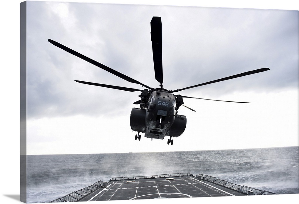 An MH-53E Sea Dragon helicopter prepares to land on the flight deck.
