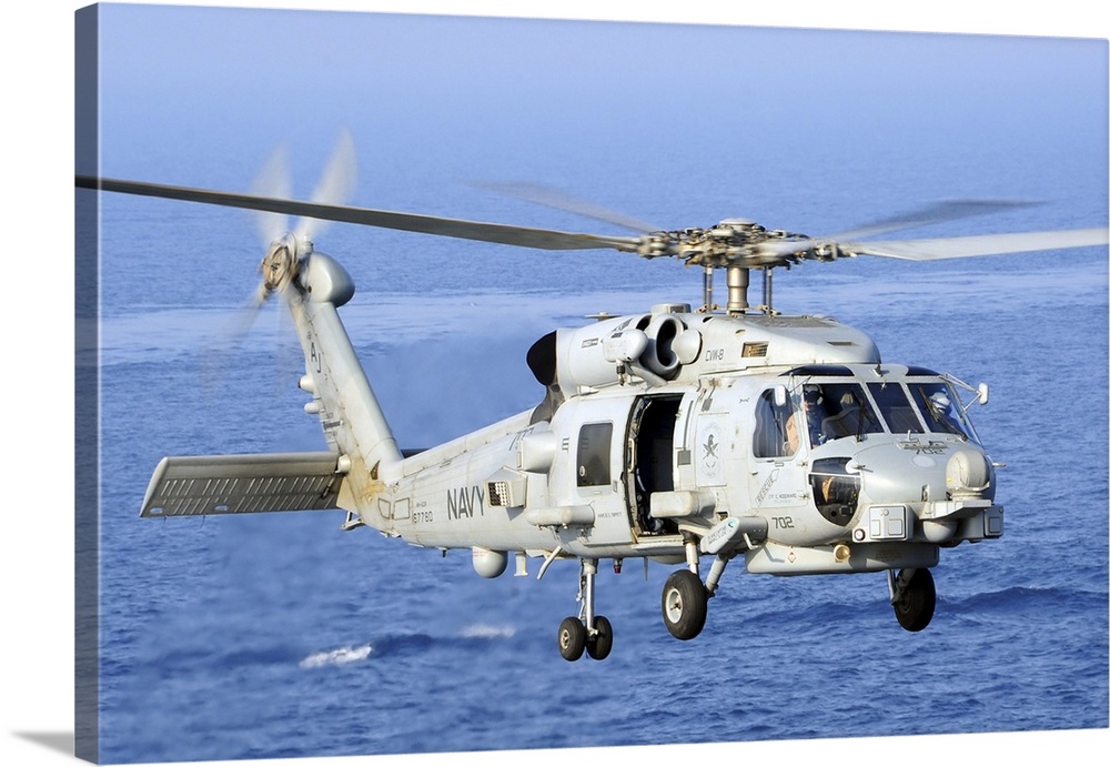 An MH-60R Seahawk helicopter takes off from the flight deck of USS George H.W. Bush.