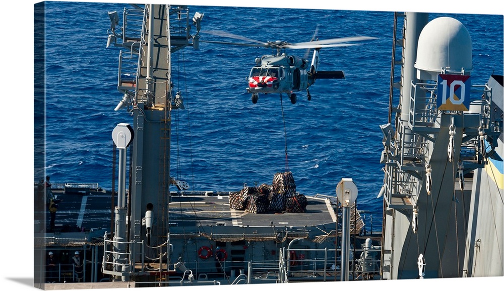 An MH-60S Sea Hawk delivers supplies to the flight deck of USS Mobile Bay.