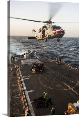 An MH-60S Sea Hawk helicopter delivers cargo to USS Mobile Bay