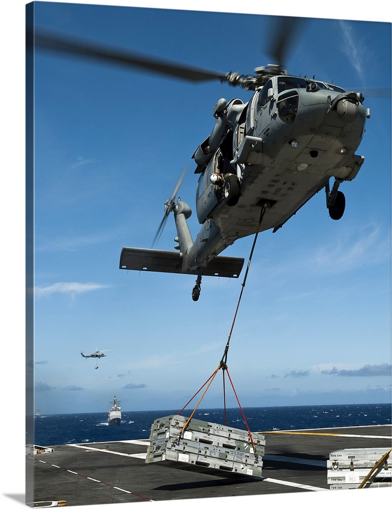 Pacific Ocean, August 7, 2011 - An MH-60S Sea Hawk helicopter lowers cargo onto the deck of the Nimitz-class aircraft carr...