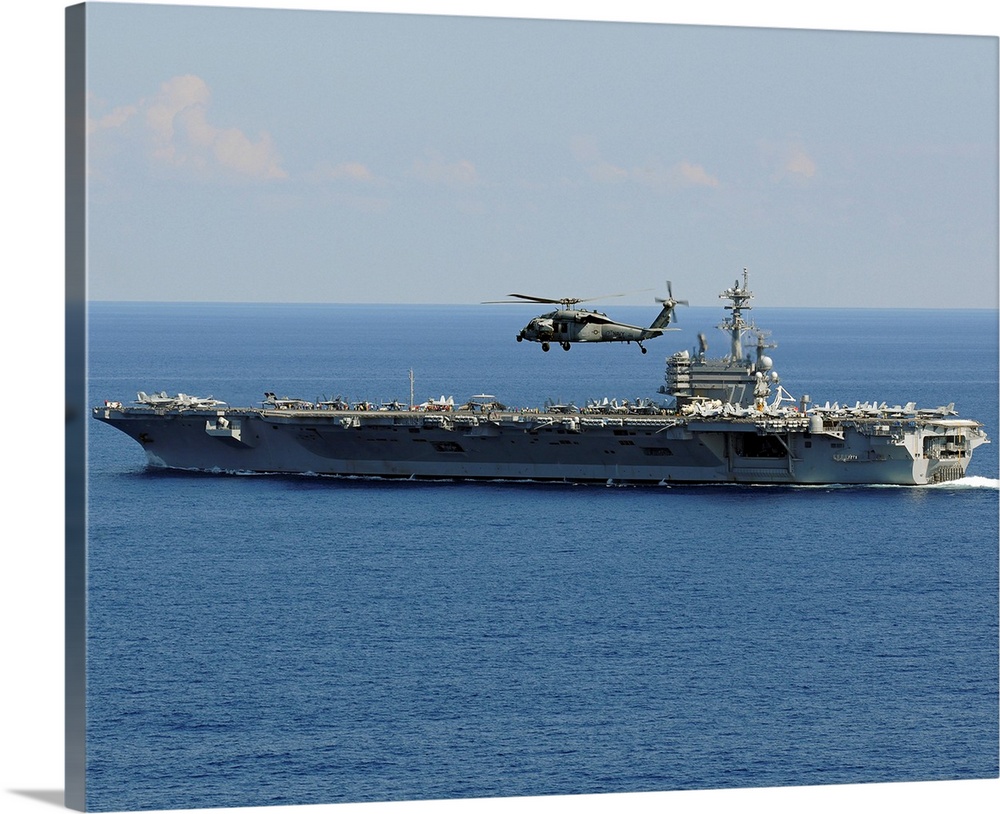 Atlantic Ocean, October 10, 2010 - An MH-60S Seahawk helicopter flies over the aircraft carrier USS George H.W. Bush (CVN-...