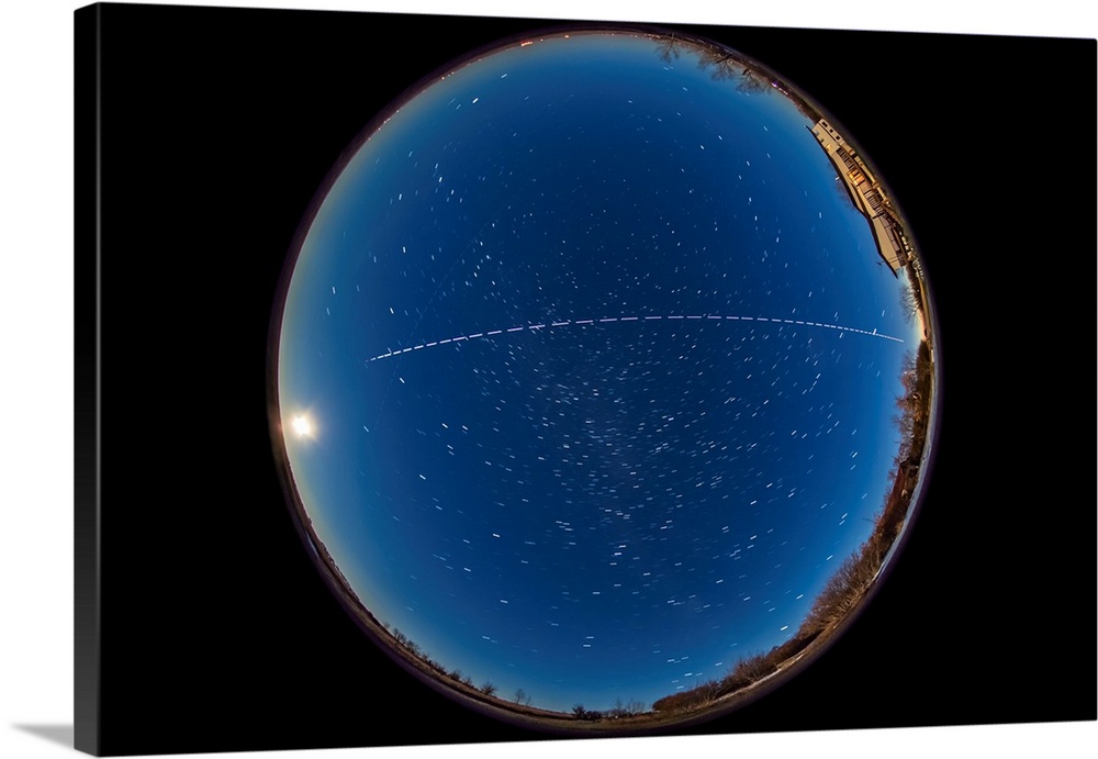 An overhead pass of the International Space Station with the full moon rising in east.