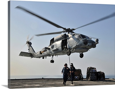 An SH-60F Sea Hawk helicopter picks up supplies from USS Gunston Hall