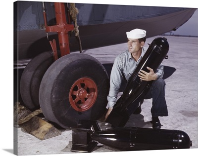 August 1942 - Sailor picking up a bomb at Naval Air Base, Corpus Christi, Texas.
