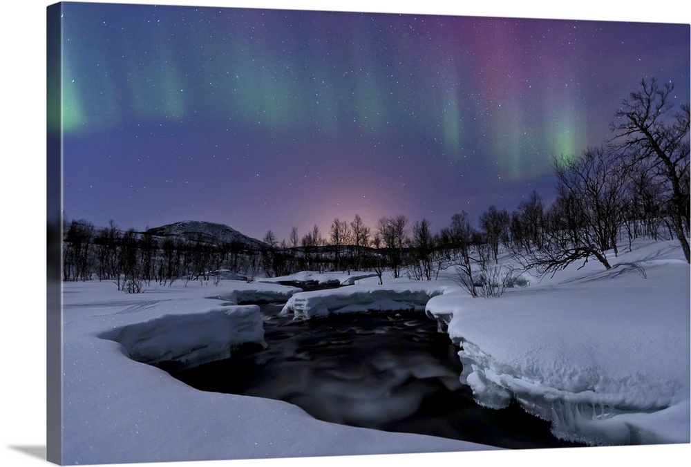 Aurora Borealis over Blafjellelva RIver in Troms County, Norway. Auroras are the result of the emissions of photons in the...