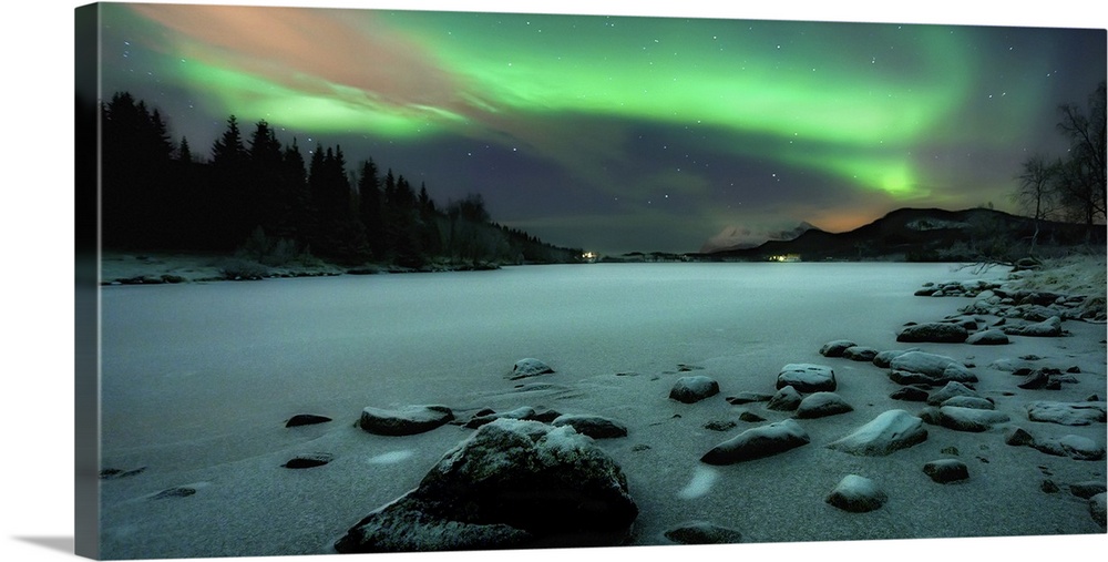 Horizontal, large photograph of the rocky shoreline of Sandvannet Lake in Troms County, Norway, with the Northern Lights s...
