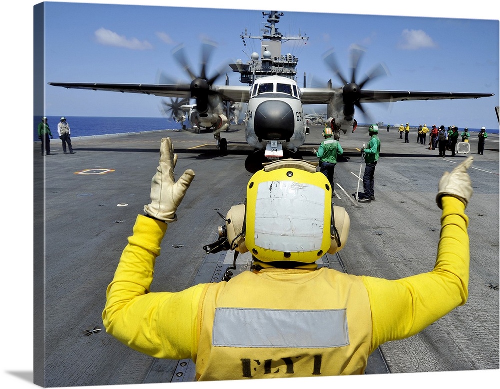 Atlantic Ocean, September 5, 2012 - Aviation Boatswain's Mate directs a C-2A Greyhound onto a catapult on the flight deck ...