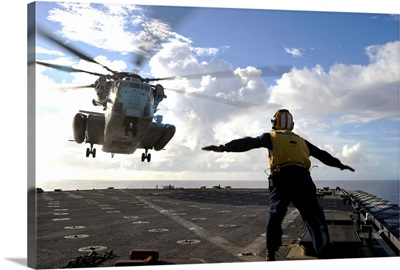 Aviation Boatswains Mate directs a CH 53E Super Stallion