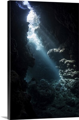 Beams Of Light Descend Into The Darkness Of A Cavern In The Solomon Islands