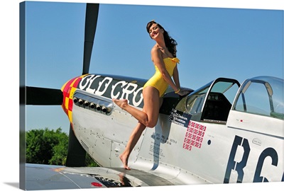 Beautiful 1940's style pin-up girl posing with a P-51 Mustang