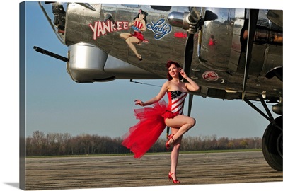 Beautiful 1940's style pin-up girl standing in front of a B-17 bomber