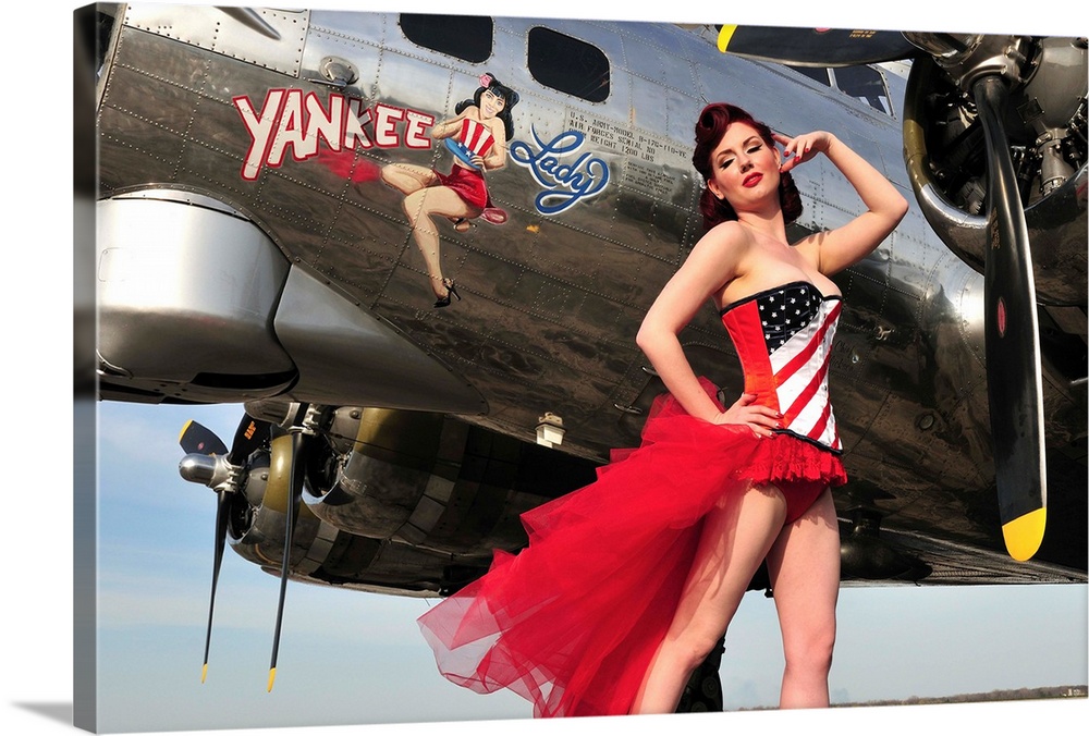 Beautiful 1940's style pin-up girl standing under a B-17 bomber.
