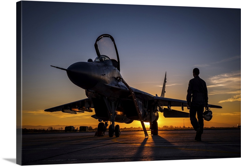 Pilot walking to a Bulgarian Air Force MiG-29 during sunset at Graf Ignatievo Air Base, Bulgaria, for a night mission sortie.