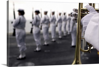 Ceremonial Honor Guard members stand at port arms during a burial at sea ceremony