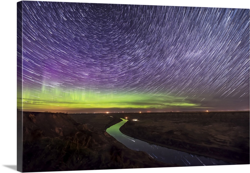 Circumpolar star trails and aurora over the Red Deer River, Alberta, Canada.