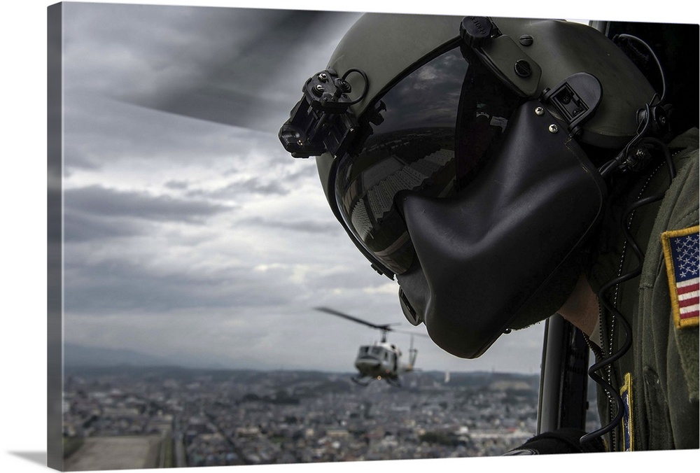 August 12, 2014 - Crew chief scans the area for potential obstacles, from a UH-1N Huey helicopter during a training missio...