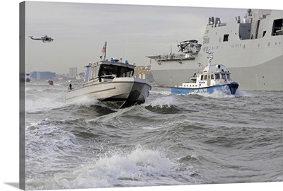 Crews from the coast guard and police departments escort USS New York