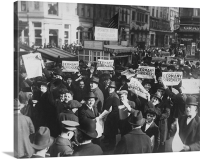Crowd at Times Square holding up Extras telling about the signing of the Armistice
