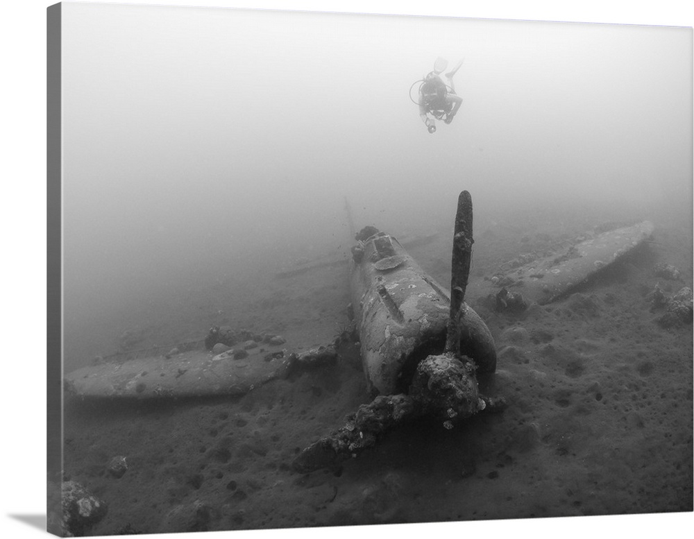 Diver explores the wreck of a Mitsubishi Zero fighter plane.
