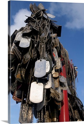 Dog tags from Marines and sailors hang in front of a memorial in Iwo Jima