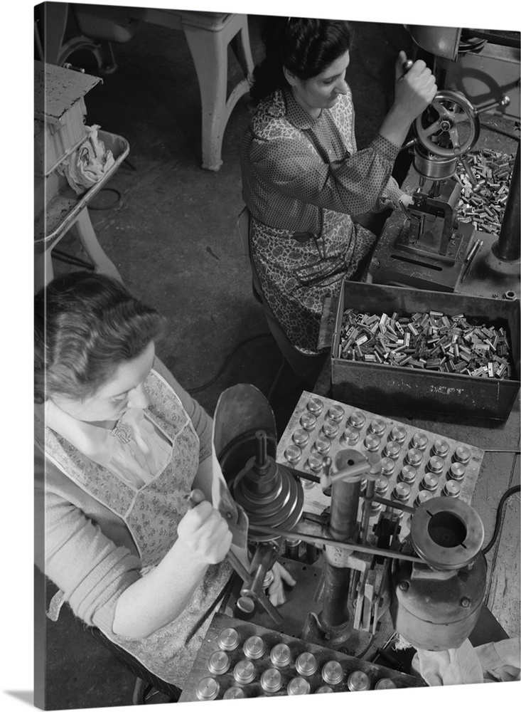 February 1942 - Worker on right drilling pressure pinholes in the heads of electric shaves, while the woman on the left dr...