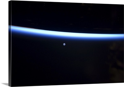 Earth's thin line of atmosphere and a gibbous moon