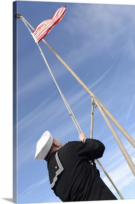 Electronics Technician Lowers The Union Jack On The Flight Deck Of USS Iwo Jima