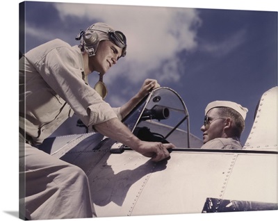 Ensign and cadet talking by cockpit of plane at Naval Air Station Corpus Christi, Texas.