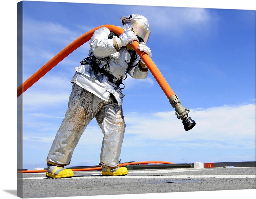 East China Sea, September 27, 2011 - Aviation Support Equipment Technician carries a charged hose across the flight deck o...