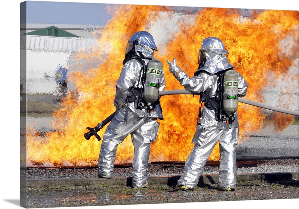 March 13, 2010 - Firefighters discuss options while training at an aircraft fire simulation at the Combat Readiness Traini...