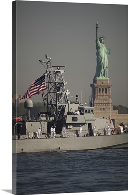 Fleet week vessels pass by the Statue of Liberty