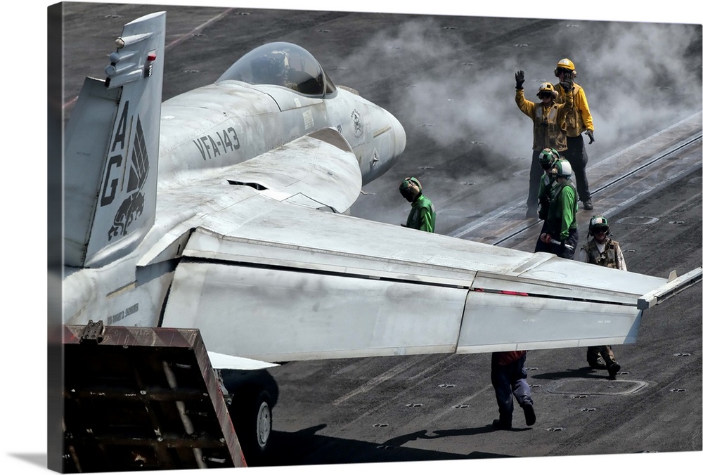 Flight deck crew position an F/A-18E Super Hornet into launch position aboard aircraft carrier USS Eisenhower. Eisenhower ...