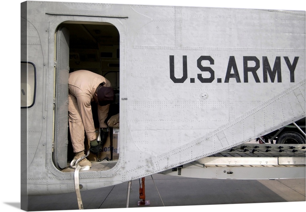 U.S. Army Flight Engineer secures equipment inside the cargo compartment of his C-23B Sherpa aircraft prior to departing f...