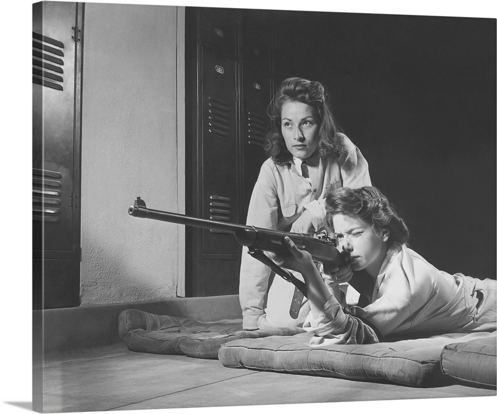 Girls practice marksmanship in high school hall, circa 1942.
