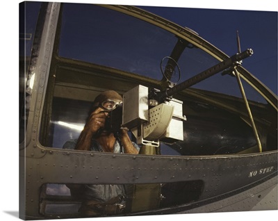 Gunner tries out a machine gun in a Navy plane, Naval Air Station Corpus Christi, Texas.