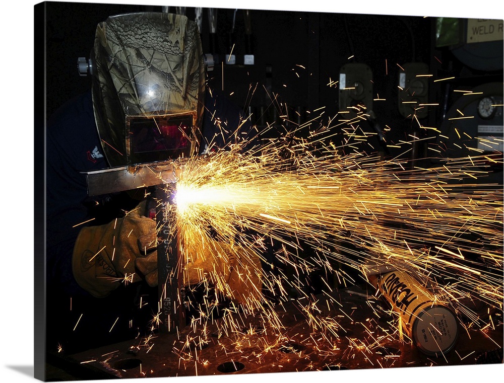 Hull Maintenance Technician welds scrap metal.
