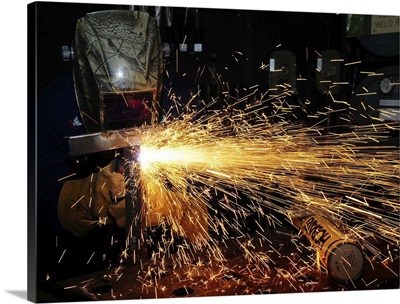 Hull Maintenance Technician welds scrap metal