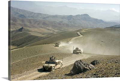 Humvees traverse rugged mountain roads