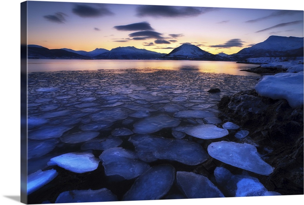Ice flakes drifting against the sunset in Tjeldsundet strait, Troms County, Norway.
