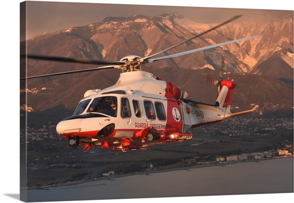 Italian Coast Guard PH-139B helicopter taken in flight at sunset.