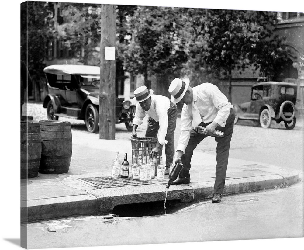 July 8, 1921 - Two men dumping seized liquor in a storm drain during the Prohibition Era.