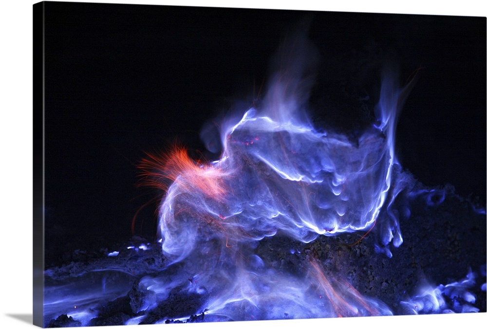 Photograph taken of a volcano that is burning sulfur which appears as puffs of smoke.