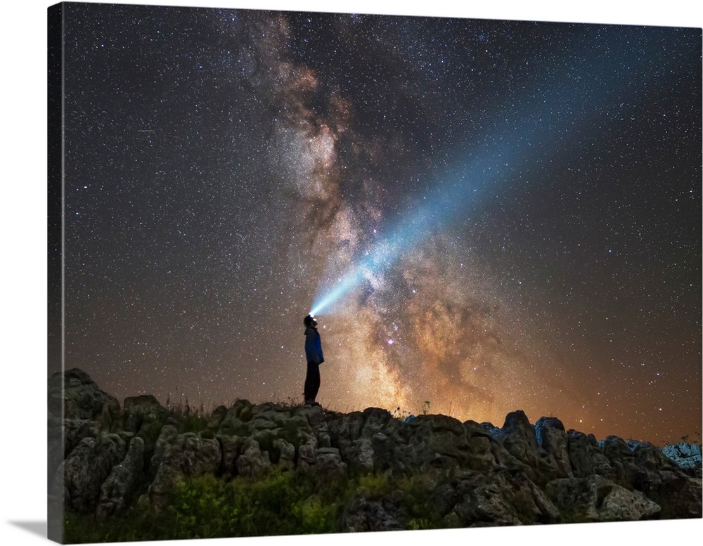 Man shining a flashlight on the Milky Way from Lago-Naki plateau in Russia.