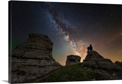 Man sits on top of Demerdzhi mountain under the Milky Way at night