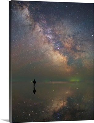 Man stands alone on Lake Elton in Russia under the center of the Milky Way